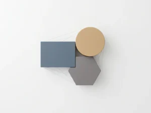 Three modular blocks in slate blue, warm sand, and charcoal arranged geometrically, connected by minimal lines on a white surface.