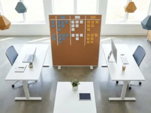 Twee minimalistische werkplekken tegenover elkaar met een gedeeld sprintbord vol gekleurde sticky notes, symbool voor internationale samenwerking op afstand.